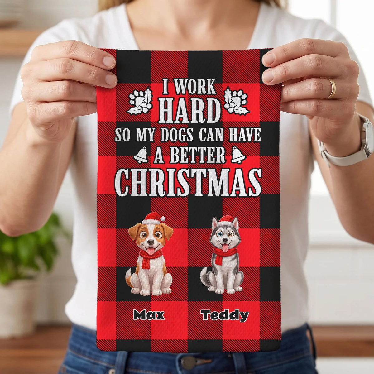 Woman holds up the Christmas Dog kitchen towel with two illustrated dogs and names