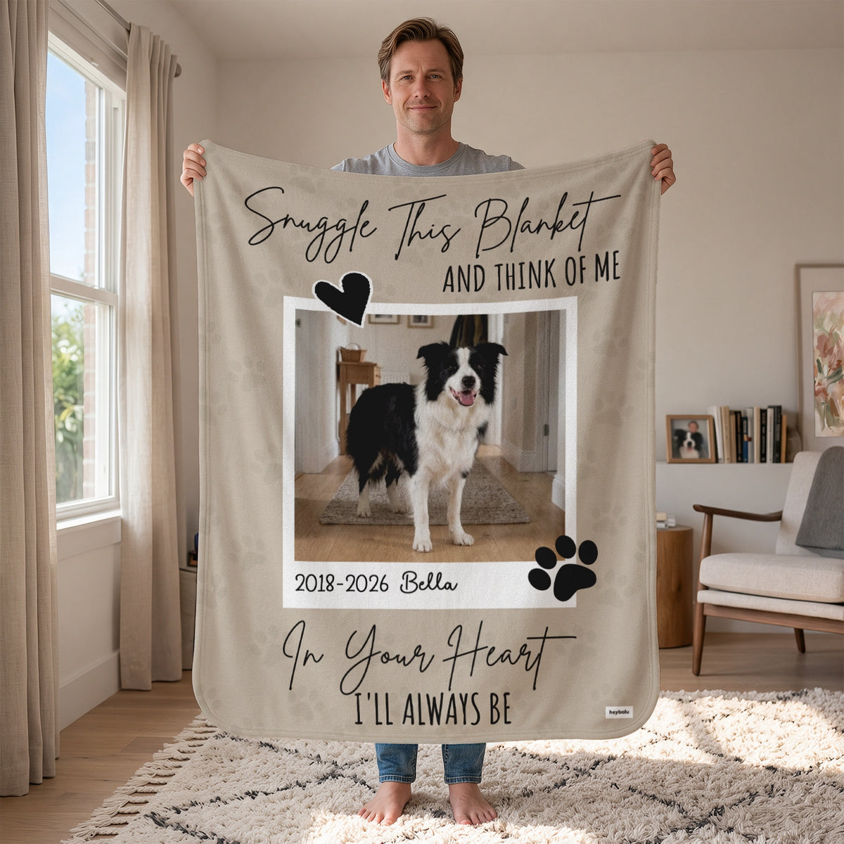 Man holds up the Dog Memorial blanket with a border collie photo, name and years