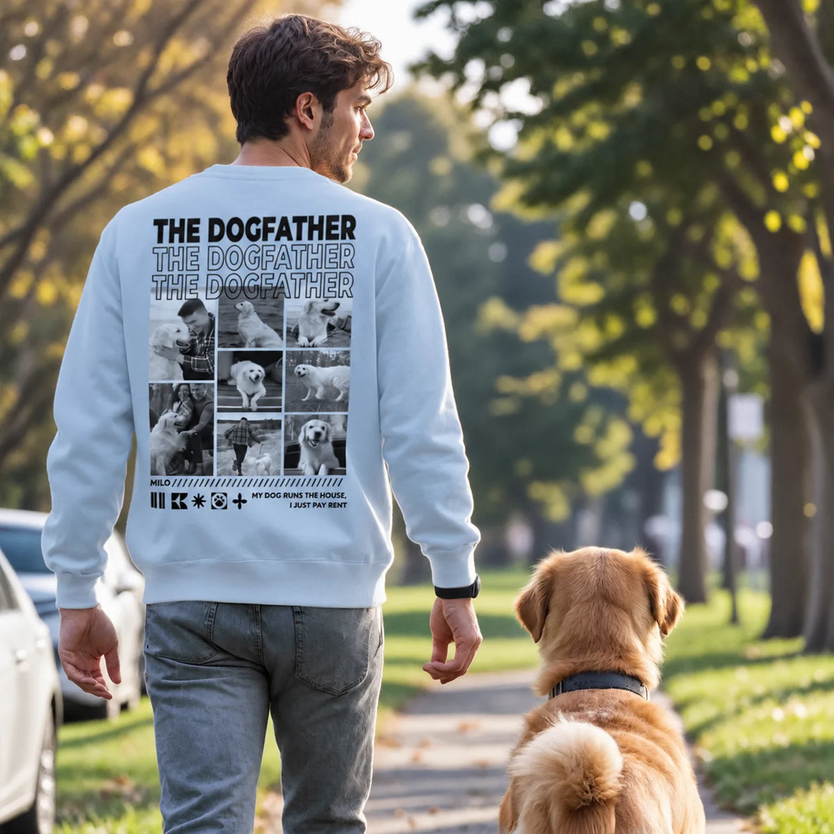Man in a light blue Dog Dad sweater, The Dogfather, walking with his Golden Retriever