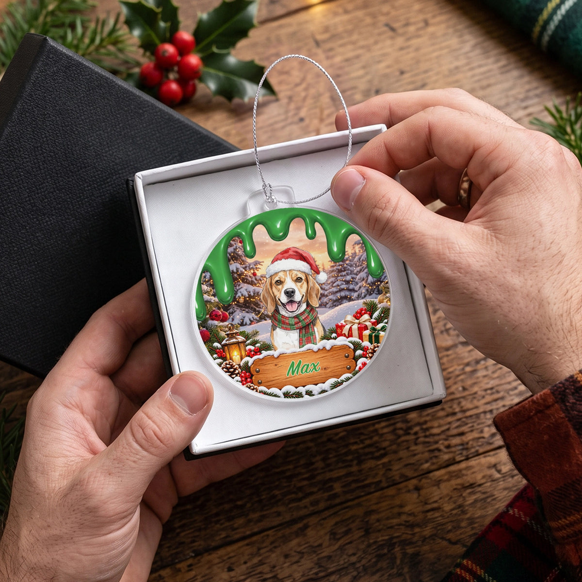 Hands placing the green ornament with a beagle named Max into a gift box