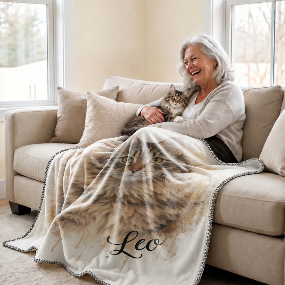 Smiling woman cuddles her cat under the Watercolor Cat blanket on the couch