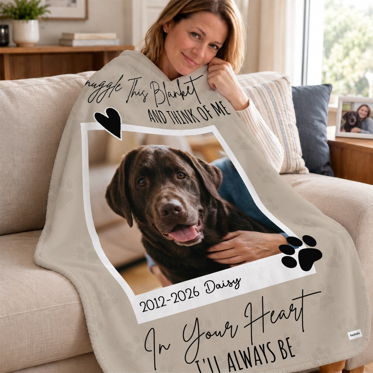 Woman cuddles up in the Dog Memorial blanket with a chocolate labrador photo on the couch