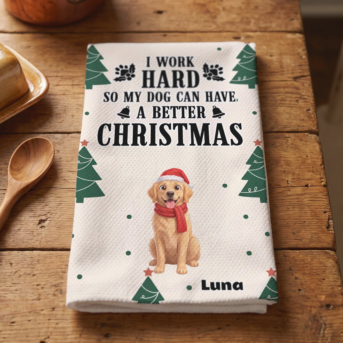 Folded Christmas Dog kitchen towel with Christmas trees and golden retriever on a wooden counter