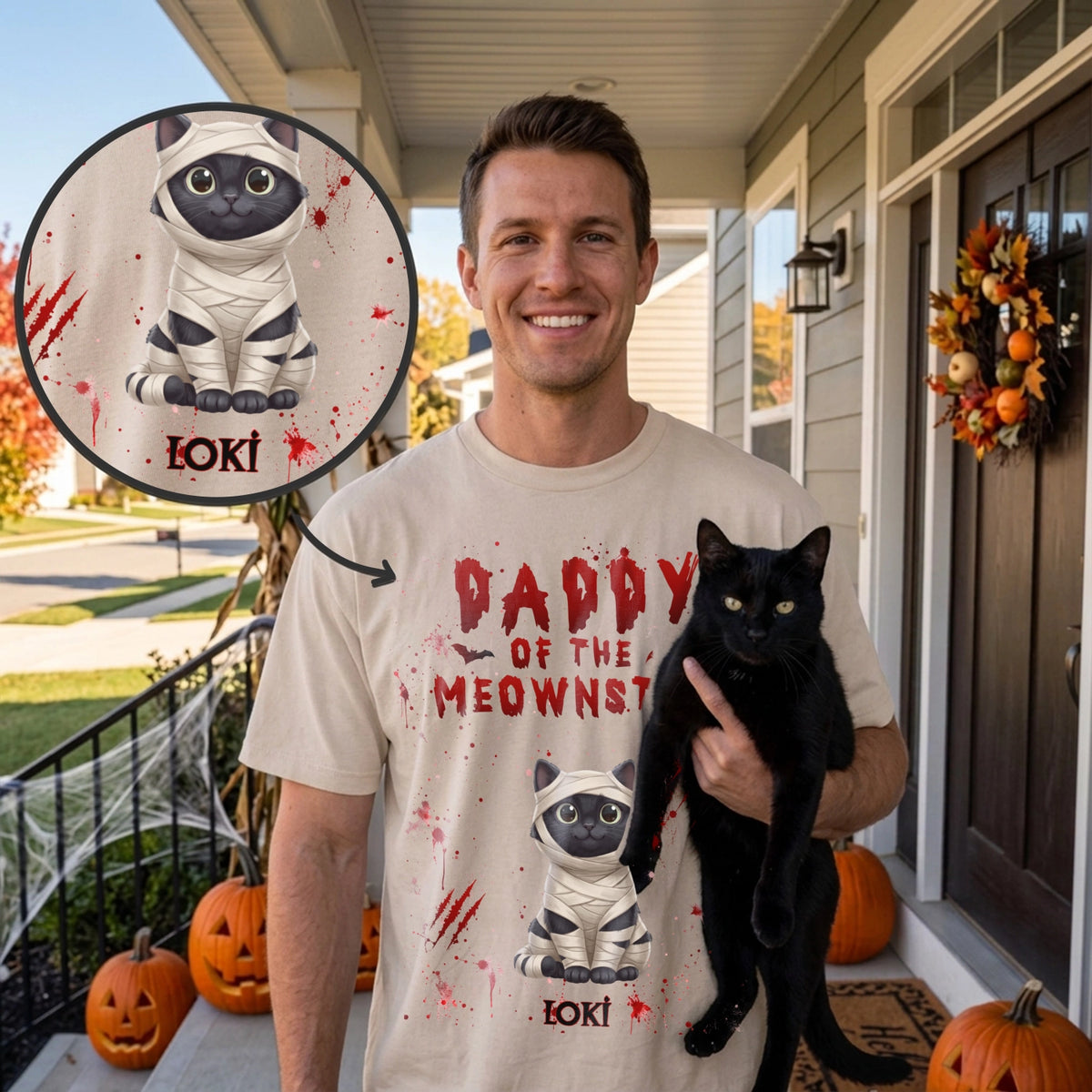 Man holding a black cat in a beige Daddy of the Meownster T-shirt with mummy cat