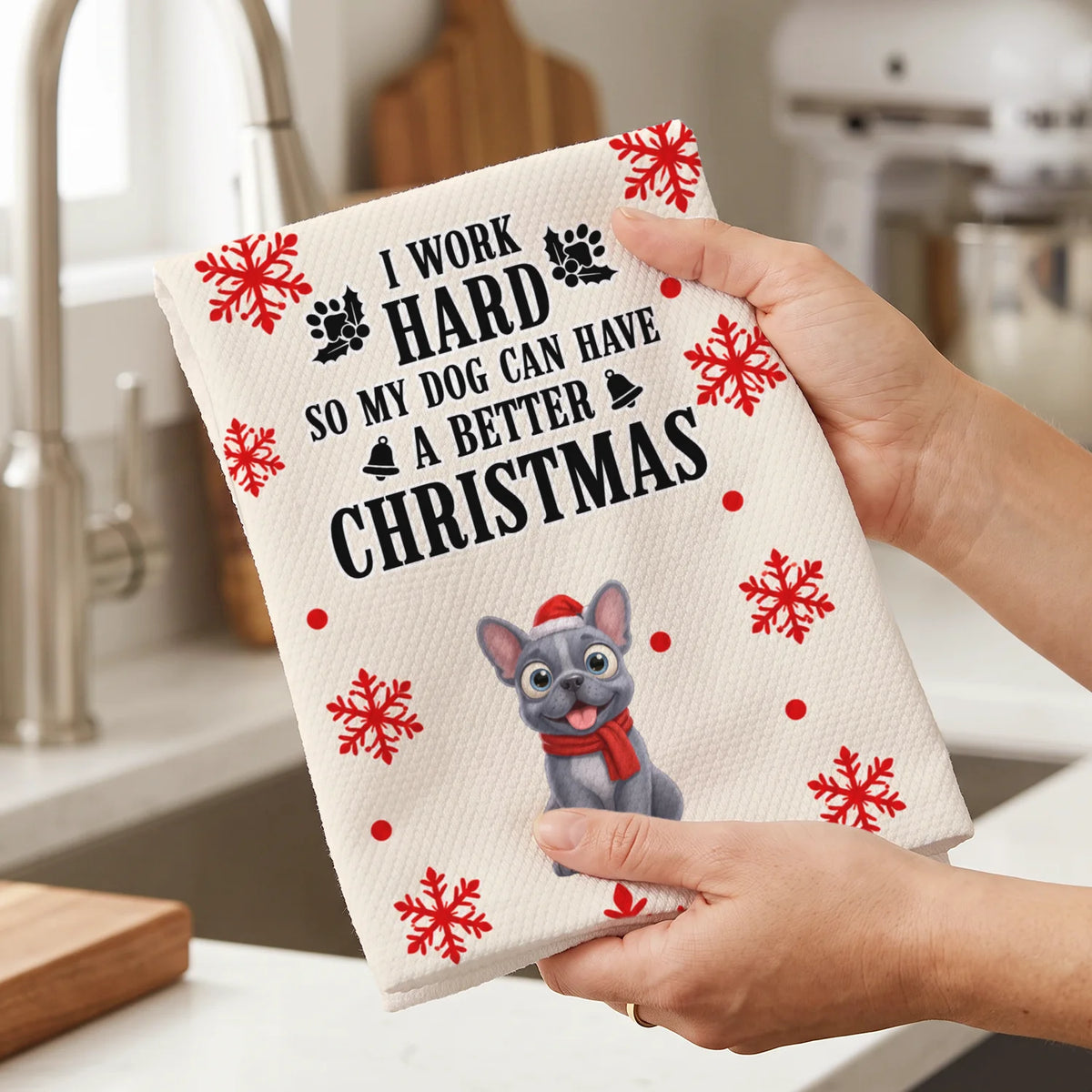 Hands hold the Christmas Dog kitchen towel with snowflakes and French bulldog illustration