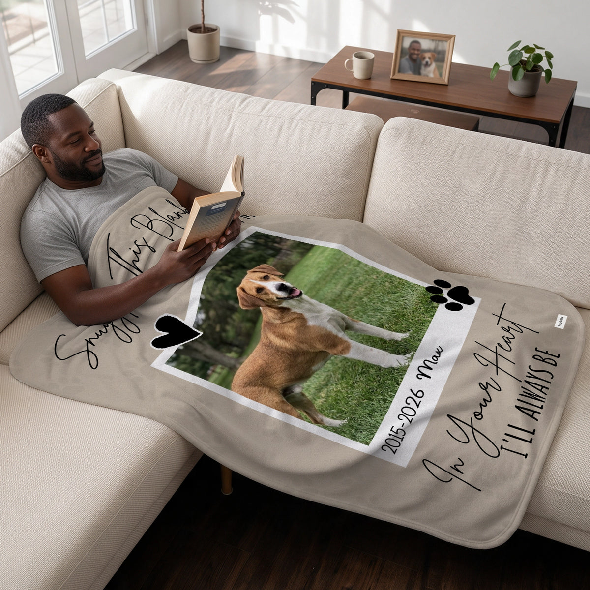 Man reads on the sofa under the Dog Memorial blanket with his dog's photo