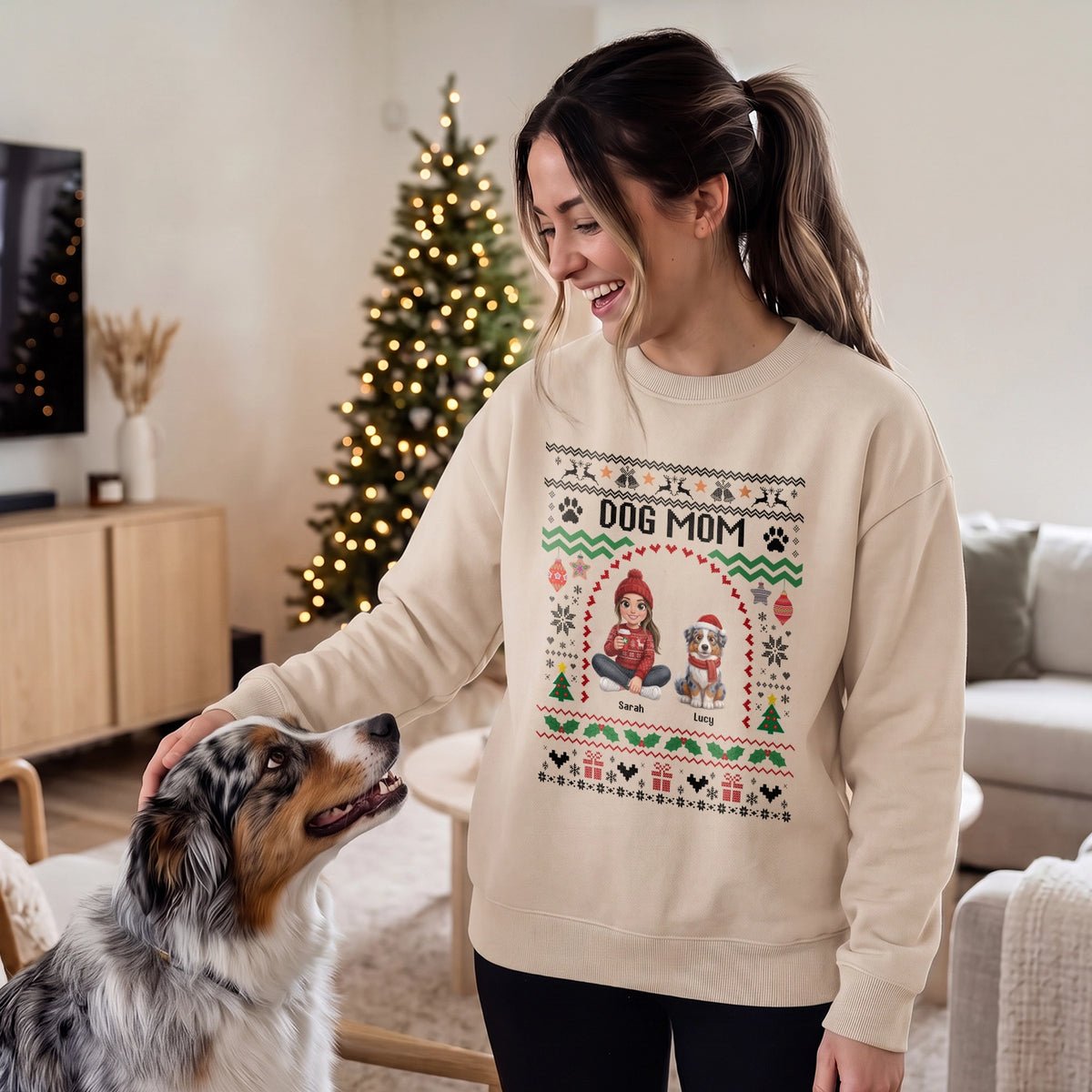 Woman in a sand Dog Mom sweater with a cartoon of her Australian Shepherd